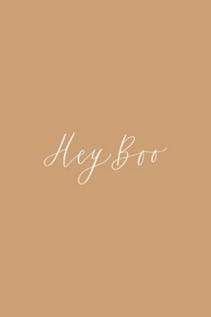 the word hey boo written in white ink on a tan background with an orange flower