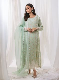 opt for elegant garden of ethereal beauty with our pastel green floral printed outfit, a masterpiece that embodies the essence of springtime elegance. The long shirt boasts with intricate cut work adorning the sleeves and hemline, The neckline is adorned with exquisite embroidery, reminiscent of blooming blossoms. Completing the ensemble with a matching organza dupatta, and pants the subtle detailing adds a touch of refinement. Shirt: Printed ShamosePants: Raw SilkDupatta: Organza Green Floral Embroidered Sets For Spring, Green Floral Embroidery Sets For Spring, Green Floral Embroidery Spring Sets, Green Sets With Dupatta For Spring, Elegant Green Sets With Floral Embroidery, Pista Green Floral Print Sets For Spring, Spring Green Sets With Chikankari Embroidery, Pista Green Floral Embroidered Dress For Spring, Pista Green Dress With Floral Embroidery For Spring