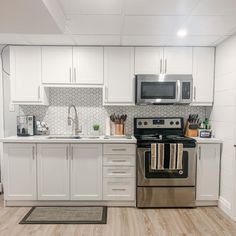 a kitchen with white cabinets and stainless steel appliances