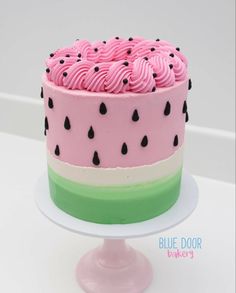 a cake with pink frosting and black dots on it