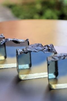 four pieces of glass sitting on top of a wooden table