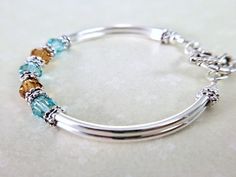 Gift the bracelet for any occasion including birthday, anniversary, bridesmaids gifts, anniversary or just because... Message me to change the crystal colors or even create a mothers bracelet. ~ 6mm lt turquoise and topaz swarovski crystals ~ antiqued silver pewter spacers ~ silver plated tube bead bangles and lobster claw Click here to return to my shop's homepage: https://www.etsy.com/shop/beadedjewelryforyou?ref=simple-shop-header-name&listing_id=604235185 Mothers Birthstone Bracelet, December Jewelry, Jewelry For Bride, Bracelet Tutorials, Topaz Bracelet, Topaz Birthstone, Mothers Bracelet, Beaded Necklace Diy, Bracelet Wedding