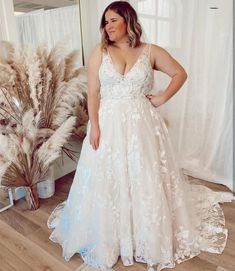 a woman standing in front of a mirror wearing a white dress with flowers on it