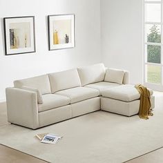 a living room with white furniture and pictures on the wall