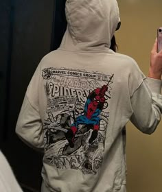 a person wearing a spider man hoodie taking a selfie in front of a mirror