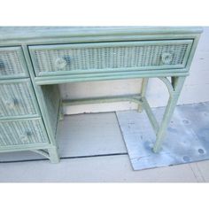 an old green wicker desk with drawers on the bottom and one drawer at the top