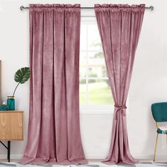 a living room with pink curtains and a blue chair