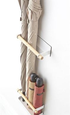 a pair of umbrellas are hanging on the wall next to a coat rack with two umbrellas