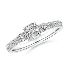 a three stone diamond ring with two diamonds on the band and an oval shaped center