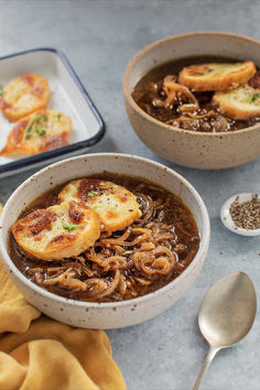 two bowls filled with soup and bread on top of a table