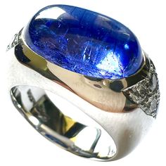 this 950/Platin ring is set with 1 Tansanite Cabouchon, oval 15,8x10mm, 9,20cts. + 12 Diamonds D/VS, 0,69cts., round 2,5mm. Ringsize is 54 and resizable. Tanzanite Stone, Pave Diamond Ring, Modern Engagement Rings, Diamond Ring Settings, Pave Ring, Modern Ring, Platinum Ring, Stone Cuts, Solitaire Ring