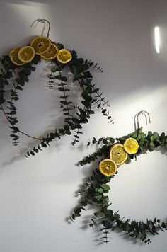 some oranges and green leaves are arranged on the wall as if they were made out of branches