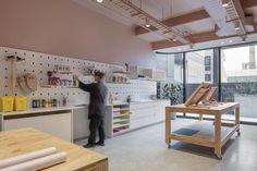 a man is standing in the middle of a room with lots of crafting supplies