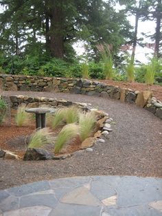 a stone path with grass and trees in the background