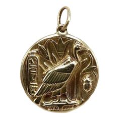 This is part of Chairish’s Fine Jewelry assortment.  This 14k gold medallion charm is part of the Kirsten’s Corner signature “Cute as a Button” collection. It's handcrafted from a Victorian-era button and features the Egyptian vulture goddess Nekhbet.  Nekhbet is the protector of Upper Egypt and its rulers. She is the patron goddess of fertility and childbirth, and was believed to be present at the birth of Osiris. She is referred to as the “Mother of Mothers, who hath existed from the Beginning Egyptian Vulture, Symbol Of Creation, Egyptian Motifs, Gold Medallion, The Protector, Egyptian Revival, Contemporary Pendant, Rustic Design, Ruby Lane