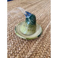 a ceramic bird sitting on top of a plate