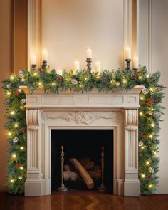 a fireplace decorated with christmas garland and lit candles