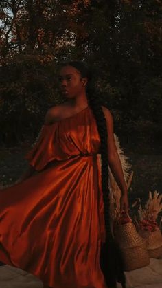 a woman in an orange dress holding a basket