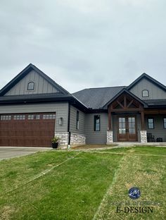 a large gray house with two garages on the front and one car door open