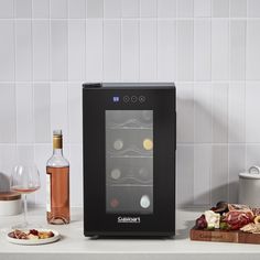 a wine cooler sitting on top of a kitchen counter next to a plate of food