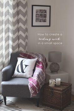 a gray chair sitting next to a window with a white and grey blanket on it