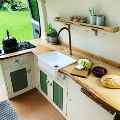 a kitchen area with sink, stove and counter top in an airstream style vehicle