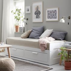 a white daybed sitting in a bedroom next to a window