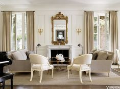 a living room with couches, chairs and a piano in front of a fireplace