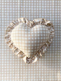 a heart shaped pillow sitting on top of a checkered table cloth