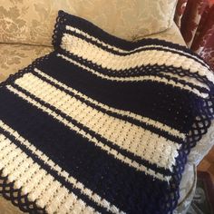 a crocheted blanket sitting on top of a couch