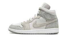 The Women’s Air Jordan 1 Mid SE “Particle Grey Suede” is a women’s-exclusive colorway of the popular lifestyle shoe in a colorway that features a unique combination of materials.  The “Particle Grey Suede” Jordan 1 Mid features hairy suede panels and Swoosh branding designed in Particle Grey and College Grey.  The overlays are contrasted by a light grey suede base.  A metal “Wings” logo is found on the collar and grey Jumpman and “Air” branding appear on the tongue tag.  Ideal for cooler temperatures, the shoe features a plush fleece-lined interior that retains warmth and provides a comfortable fit to the wearer. Particle Grey Jordan 1, Jordans Gray, Womens Air Jordan 1, Womens Air Jordan, Air Jordans Women, Nike Sacai, Air Jordan 1 Mid Se, Womens Air Jordans, Wings Logo