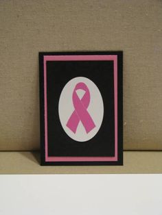 a pink ribbon on a black and white square