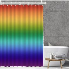 a rainbow shower curtain in a bathroom with a bathtub and rug on the floor