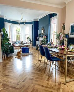 a living room filled with furniture and a cat sitting on the floor next to a table