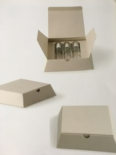 an open box with three bottles in it and the lid is closed to show the contents