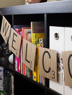 a book shelf with some books on it and clothes pegs hanging from the top