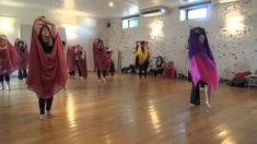 a group of young women dancing on top of a wooden floor