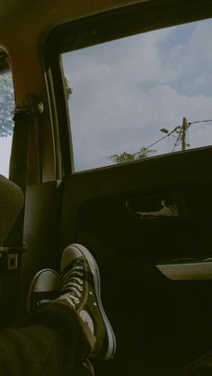 someone is sitting in the back seat of a car with their feet on the dashboard