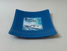 a small blue plate with writing on it