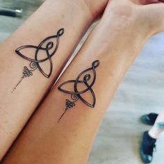 two people with matching tattoos on their legs, one has an arrow and the other is a