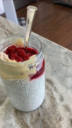 a jar filled with chia pudding on top of a counter next to a spoon