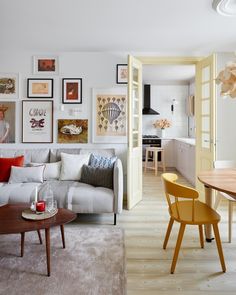 a living room filled with furniture and pictures on the wall