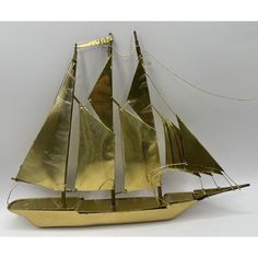 a model sailboat made out of gold foil