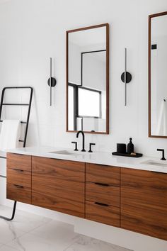 a bathroom with two sinks and mirrors on the wall above them is white tile flooring