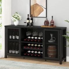 a black cabinet with wine bottles and glasses on it in front of a wall mounted mirror