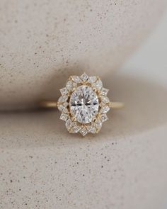 an engagement ring with a center diamond surrounded by smaller diamonds