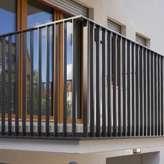 a balcony with metal railings and sliding glass doors on the side of a building