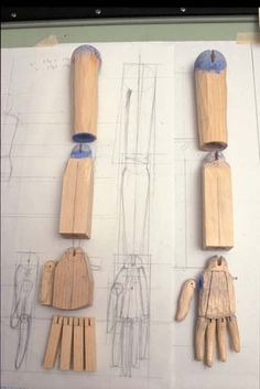 several wooden pegs are attached to the back of some clothes pins on a piece of paper