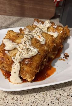 a white plate topped with french toast covered in sauce