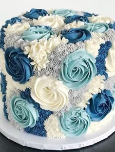 there is a blue and white cake on the platter with silver trimmings